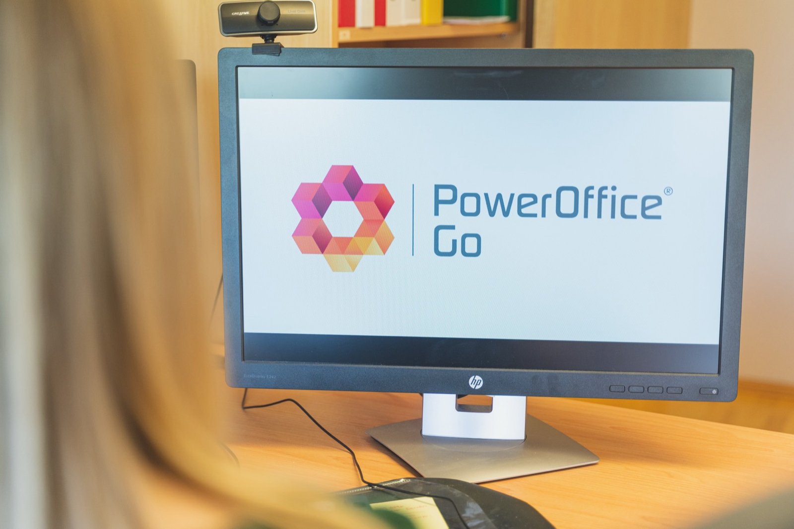 Skjerm med PowerOffice Go på et skrivebord